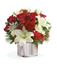 Picture of Christmas flower arrangement with red roses and white lilies in ceramic vase.