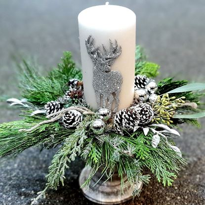 Picture of Festive Christmas arrangement decoration with raindeer candle in white and silver color.